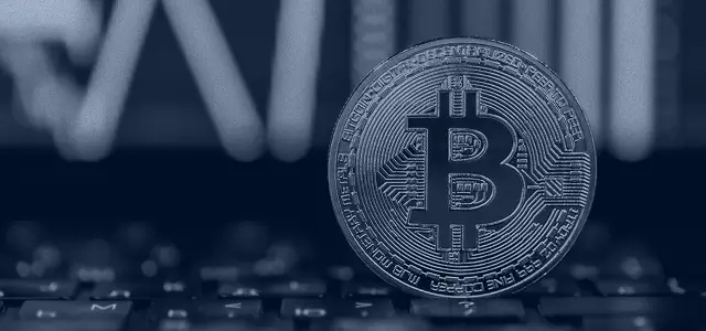 Bitcoin coin standing up on a keyboard